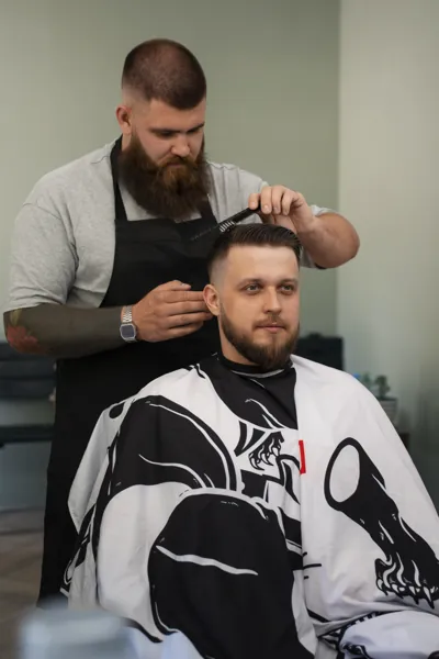 Professional gents hair salon with a skilled barber giving a modern haircut to a male client in a clean, stylish salon environment.