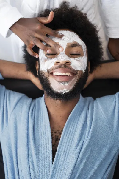 Professional gents salon facial treatment being performed on a male client in a clean and relaxing salon environment.